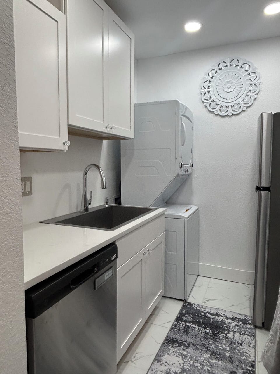 Kitchen with Full size stacked washer and dryer.