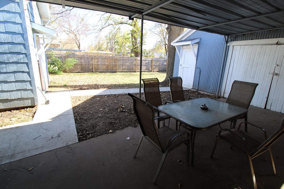 Outdoor covered dining area with charcoal grill.