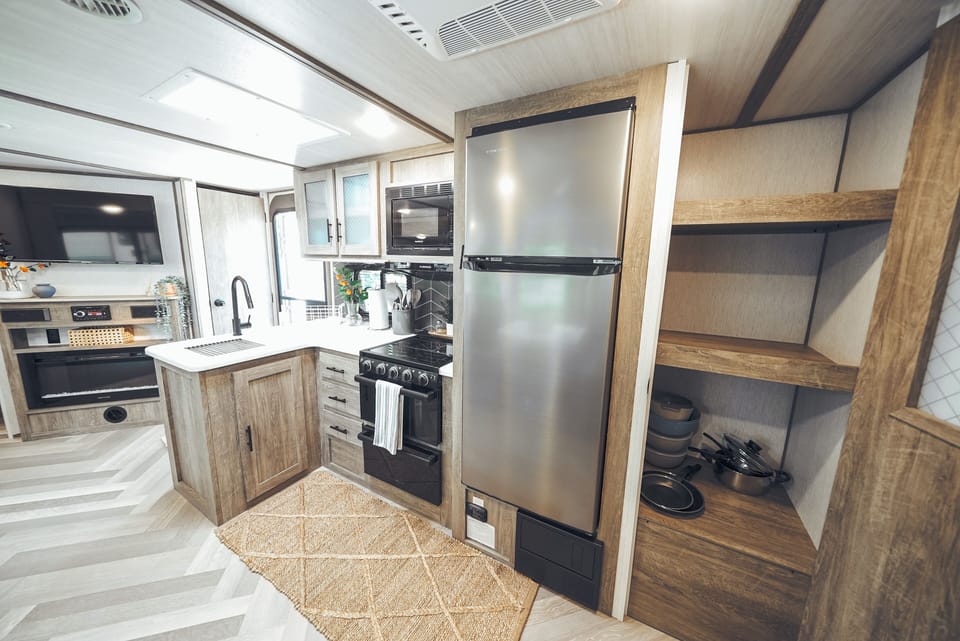 Kitchen is equipped with stove, oven, toaster, coffee maker, microwave, & dishes