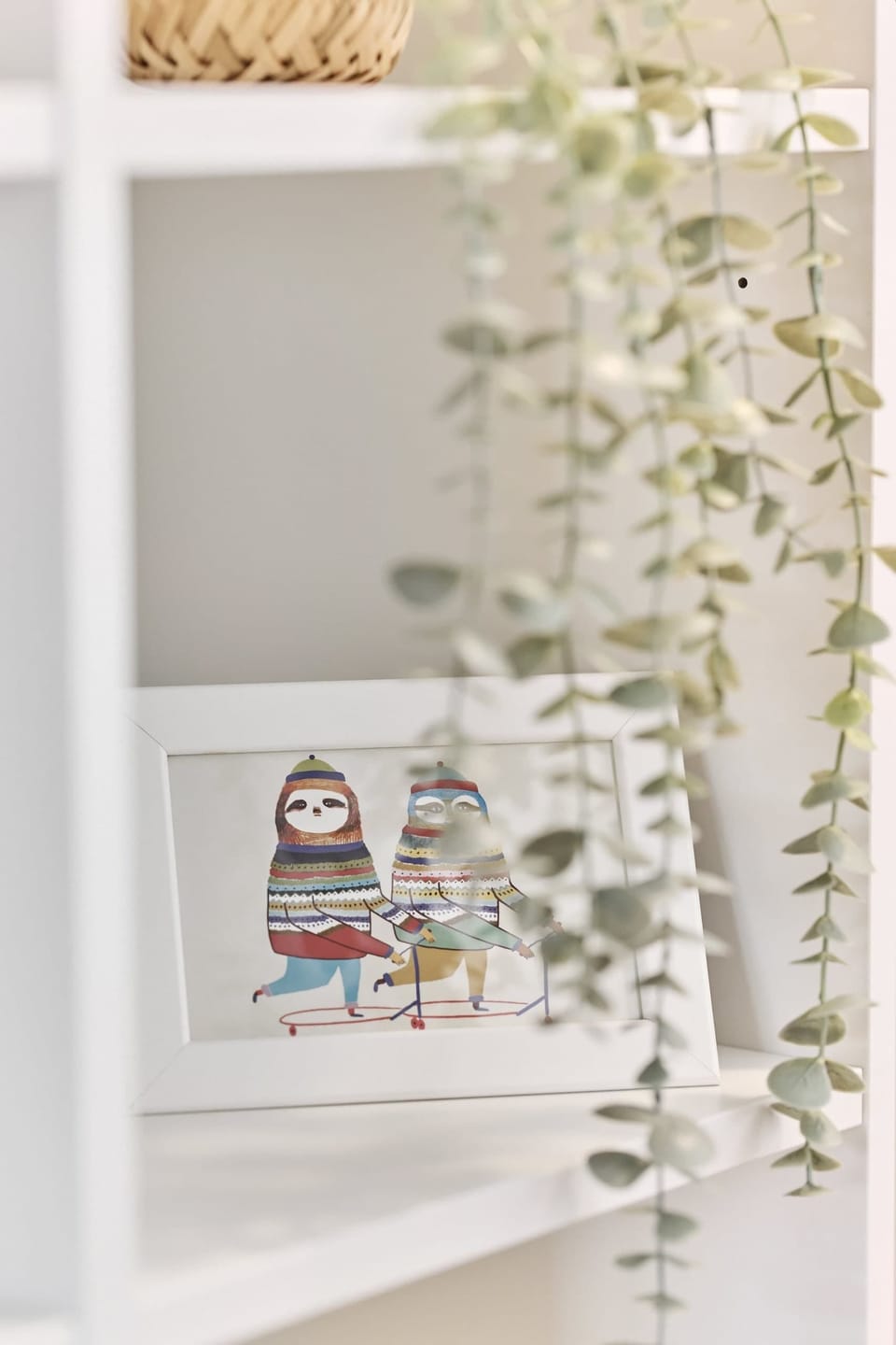 A white shelf with decorative accents, including greenery.