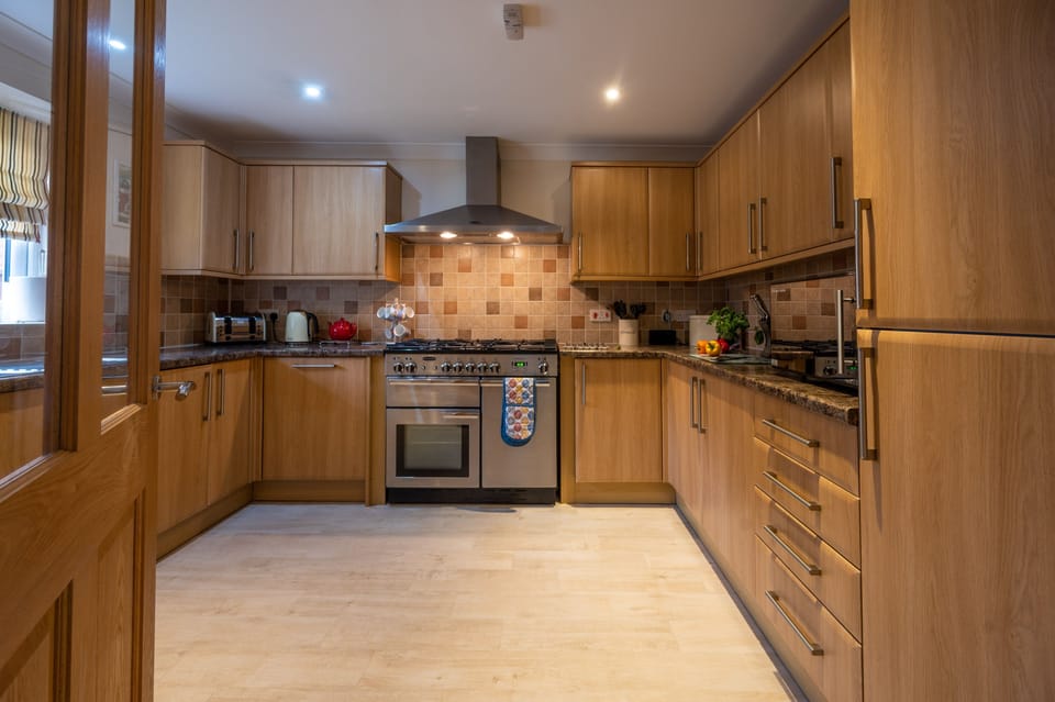 Ground floor: Well-equipped kitchen with an electric range cooker and gas hob, fridge/ freezer, microwave, dishwasher, and washing machine