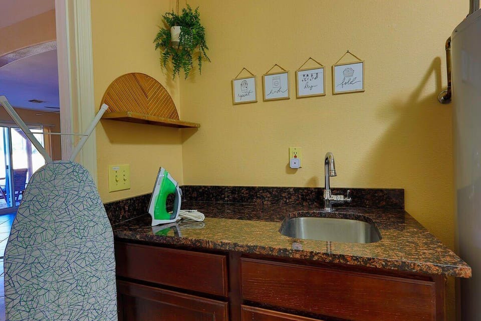 laundry room with sink, iron and ironing board for guest use. 