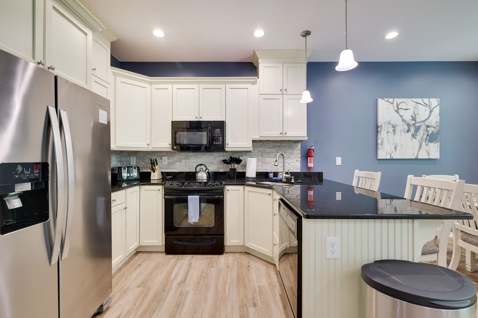 The kitchen features new appliances and is well stocked with cooking utensils.