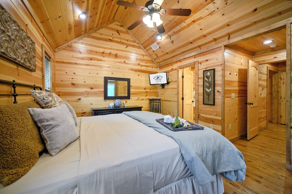 Slip into your cozy retreat, where warm wood tones and cathedral ceilings create a peaceful haven for restful nights and lazy mornings.