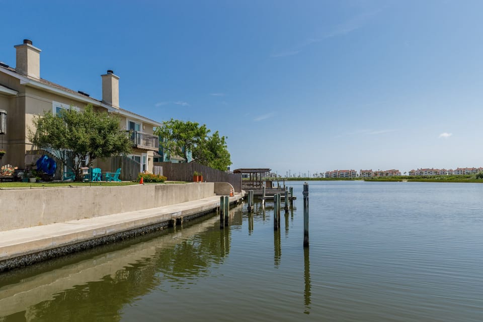 Waterfront property with private dock and boat slip on calm lake waters surrounded by residential community.
