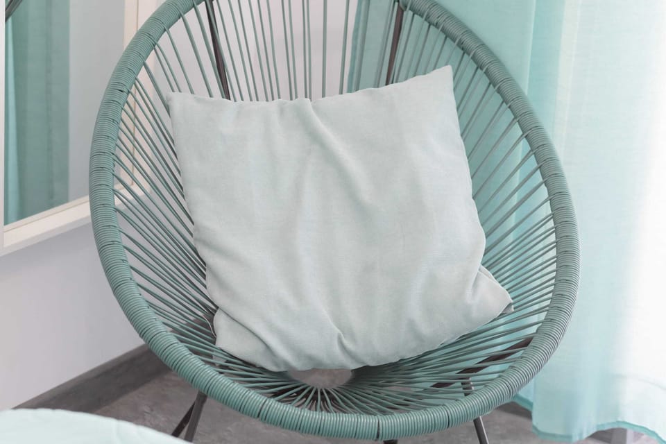 Close-up of a turquoise chair in the bedroom.