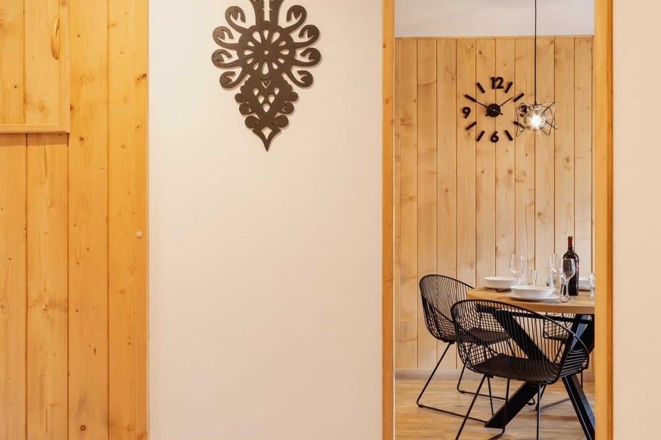 A modern entryway with a large mirror and hooks for coats, offering both style and functionality.
