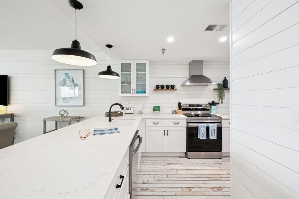 Your bright, modern kitchen awaits with sleek white countertops, stylish pendant lighting, and everything you need to create memorable meals during your stay.