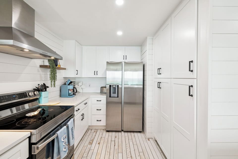 Your modern white kitchen features stainless steel appliances and sleek countertops, creating the perfect space for preparing memorable meals.