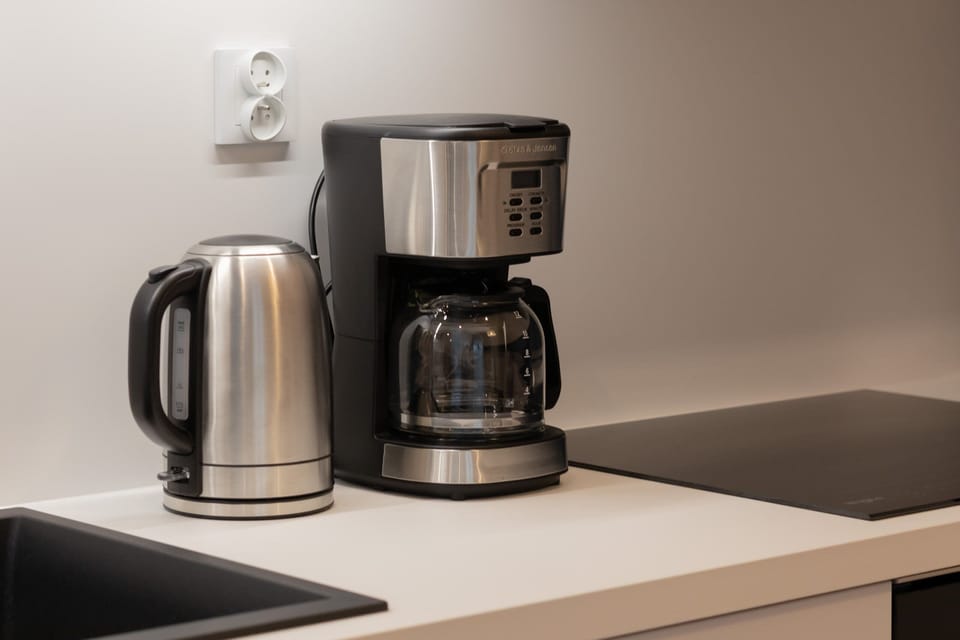 A close-up of kitchen appliances including a coffee maker and kettle.
