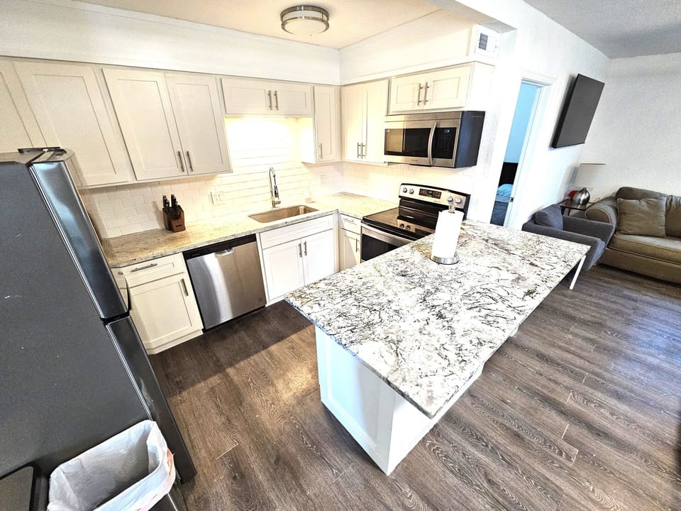 Kitchen with stainless steel appliances and granite countertop.