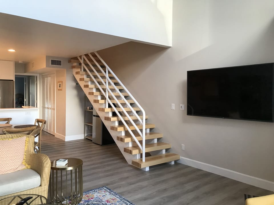 Large screen smart TV, custom stairs lead to the second floor main suite