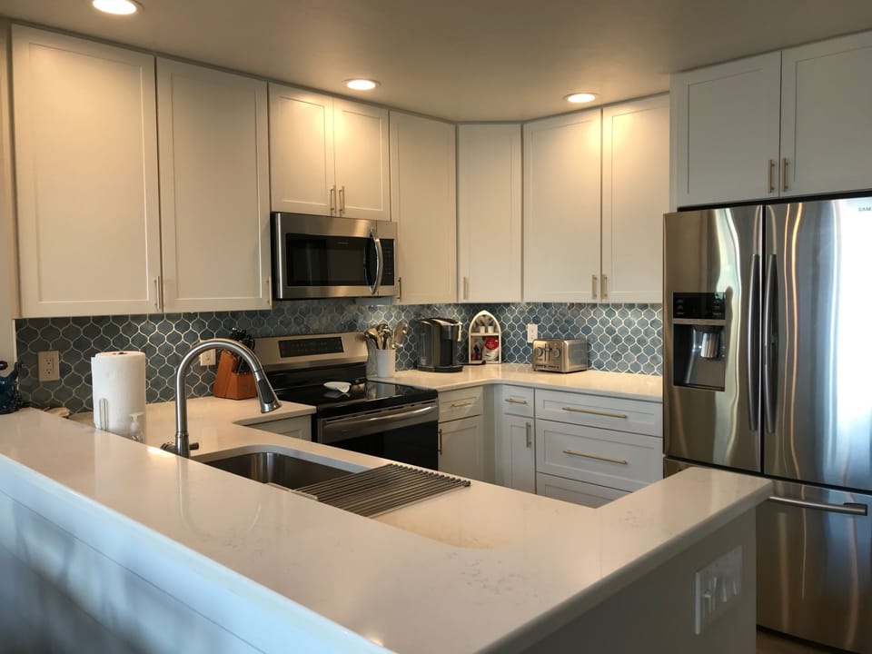 Chef's kitchen includes induction range, quartz counters & stainless appliances