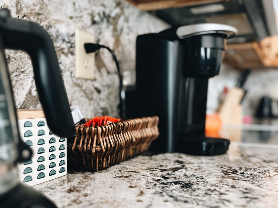 Cozy coffee station with single-serve brewer on granite countertop