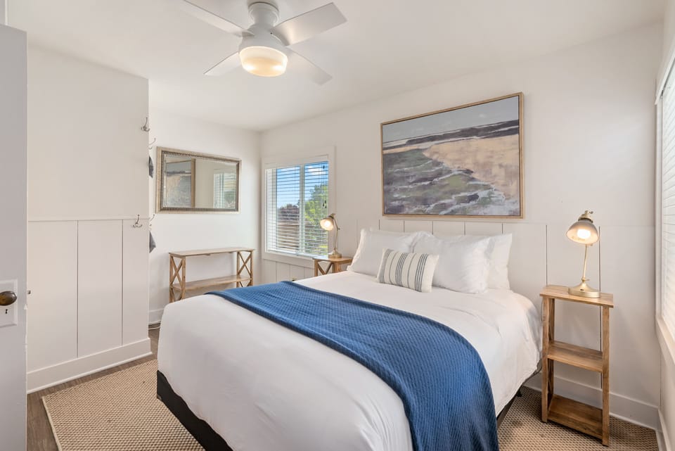 A queen bed and bright windows make the bedroom feel restful