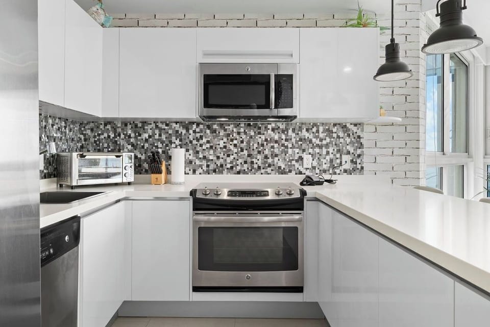 Your fully equipped kitchen features modern appliances and stylish mosaic backsplash, ready for you to prepare delicious meals during your stay.
