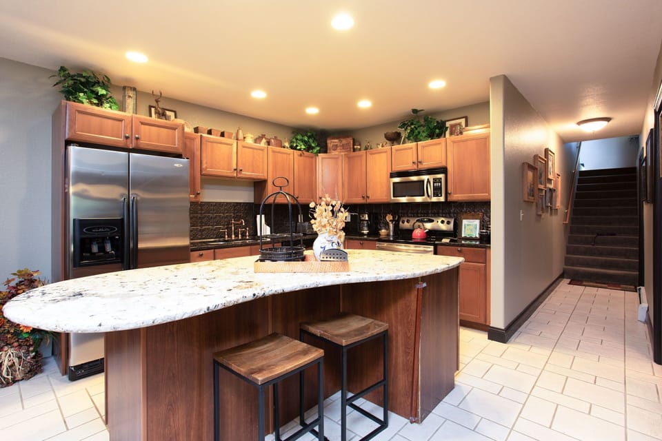 Kitchen with stainless steel appliances, granite countertops and large island.