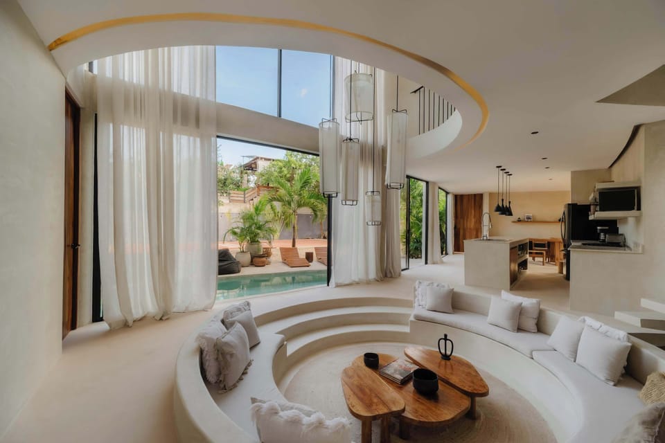 Curved seating, jungle views & floor-to-ceiling glass. Pure living.