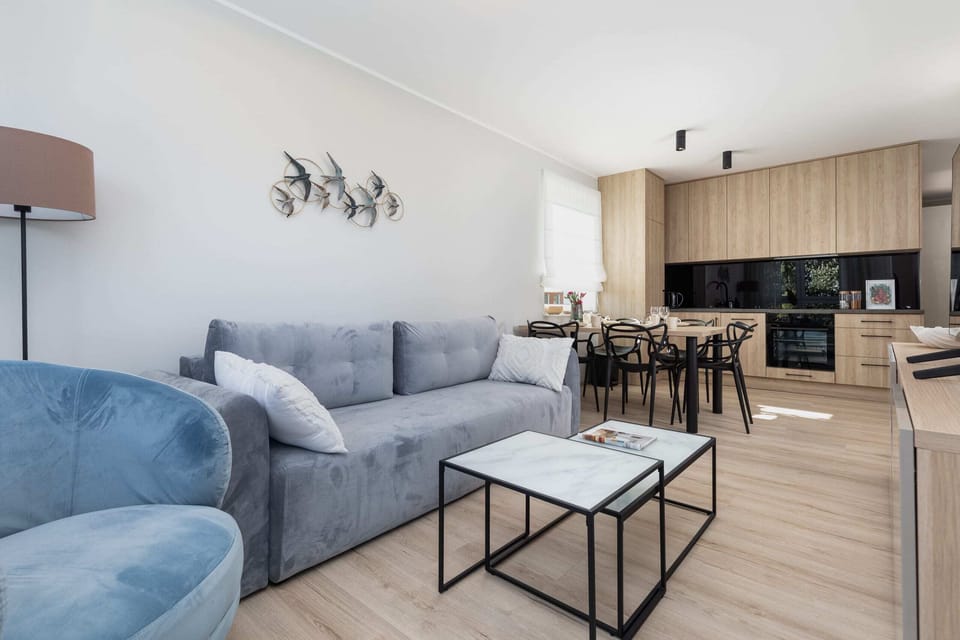A cozy corner of the living room, with a modern blue sofa and a decorative coffee table.
