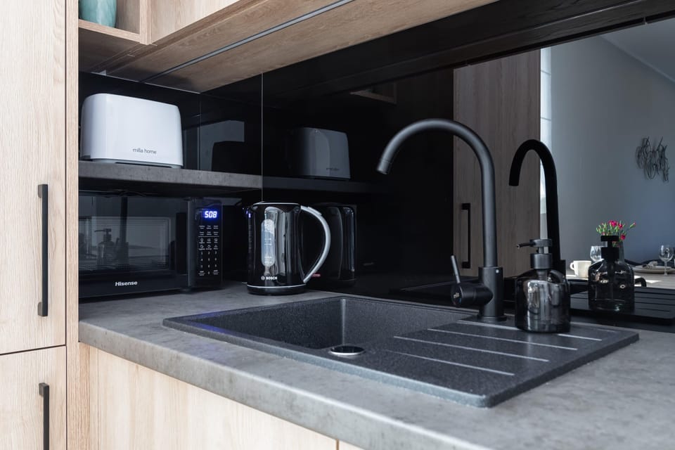 A detailed view of the kitchen sink area, including a microwave, toaster, and other appliances.
