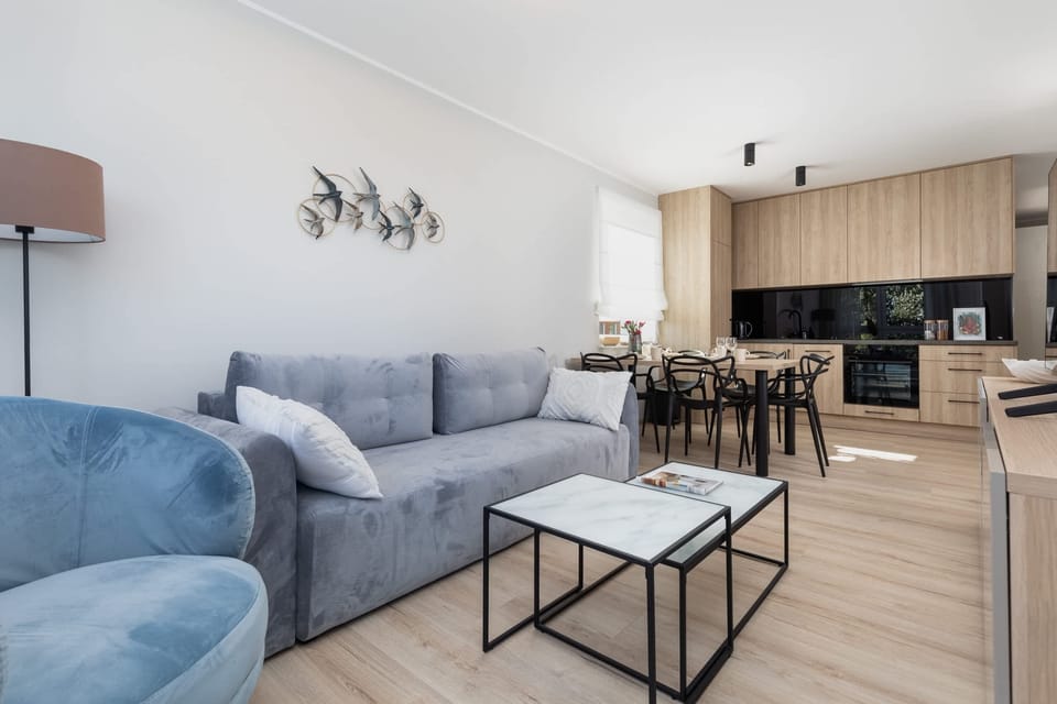 A cozy corner of the living room, with a modern blue sofa and a decorative coffee table.
