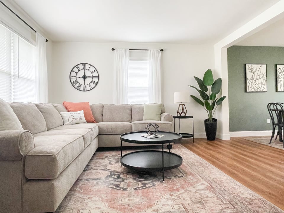 The bright and cheery living room is open to dining area and kitchen.