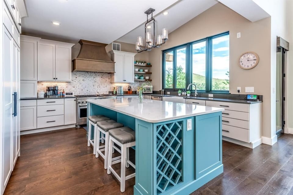- Chef’s kitchen stuns with a bold blue island, quartz counters, and gas range
- Built in wine rack, open shelving, and modern lighting add both style and ease
- Gather around the island for meals, wine, or mountain view conversations

