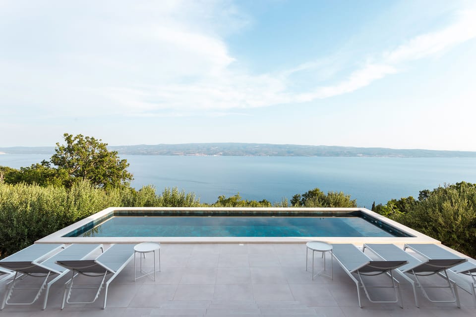 Villa Marmoris pool area with sunchairs and outdoor shower. 