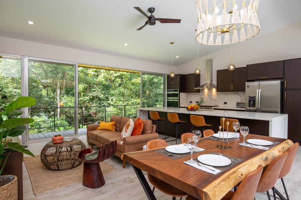 Open Plan Living Room + Chefs Kitchen, with glass walls to deck and jungle.