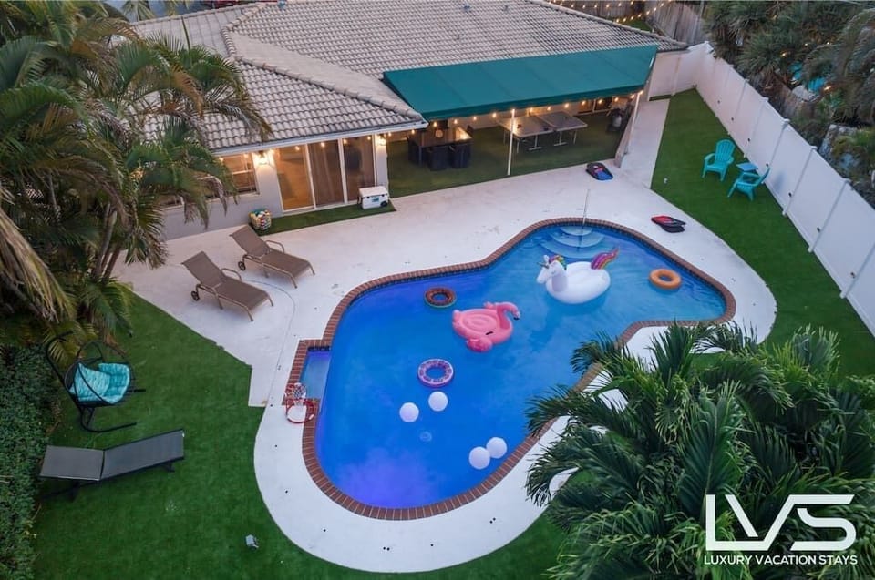 Heated Waterfront Pool in expansive back yard covered in artificial turf, ping pong table, 5 hole putting green, outdoor patio table, 2 kayaks, outdoor TV, BBQ Grill & separate Blackstone griddle. 