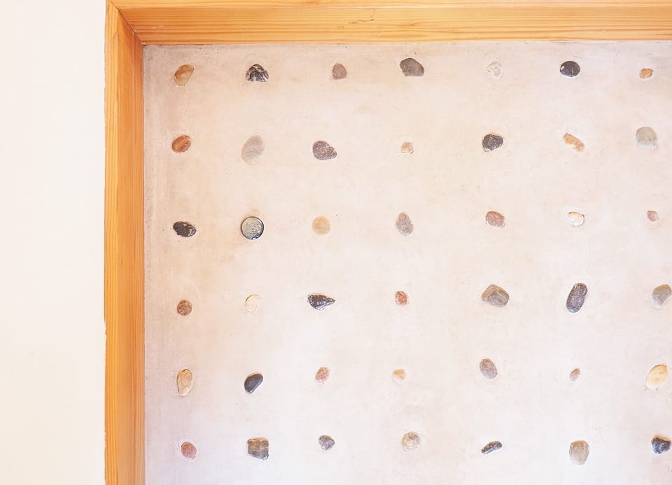Colorful natural stones are embedded in the entrance dirt floor.