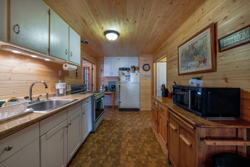 Galley kitchen (note, no dishwasher) with full-size fridge, coffee and tea station, microwave, and oven/stove