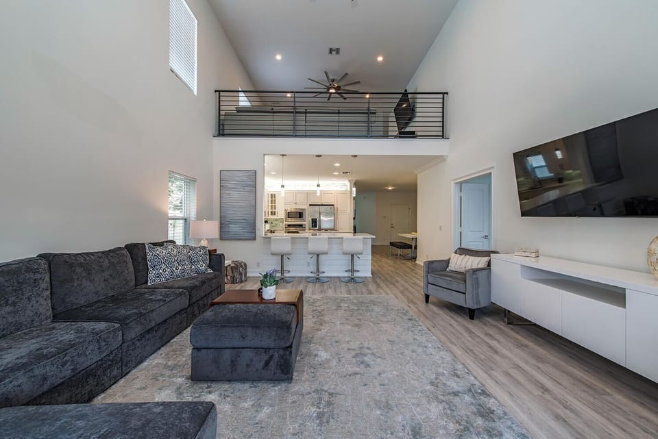 A wide-open floor plan with plush seating and views to the upstairs loft — designed for relaxation and gathering on vacation time