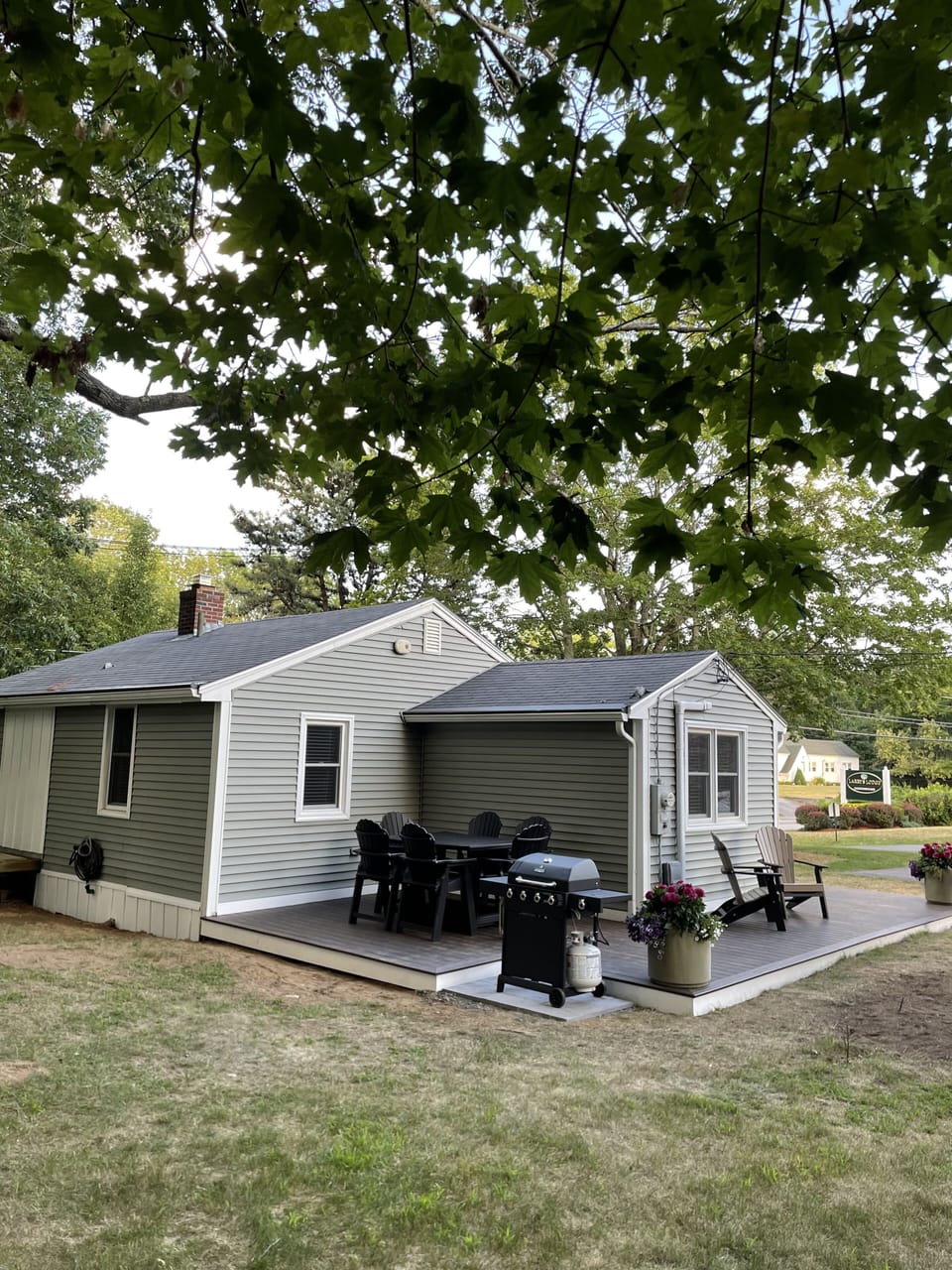 Wrap around porch deck, back yard with gas grill.