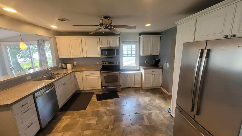 Open kitchen with dishwasher, range, microwave and garbage disposal.