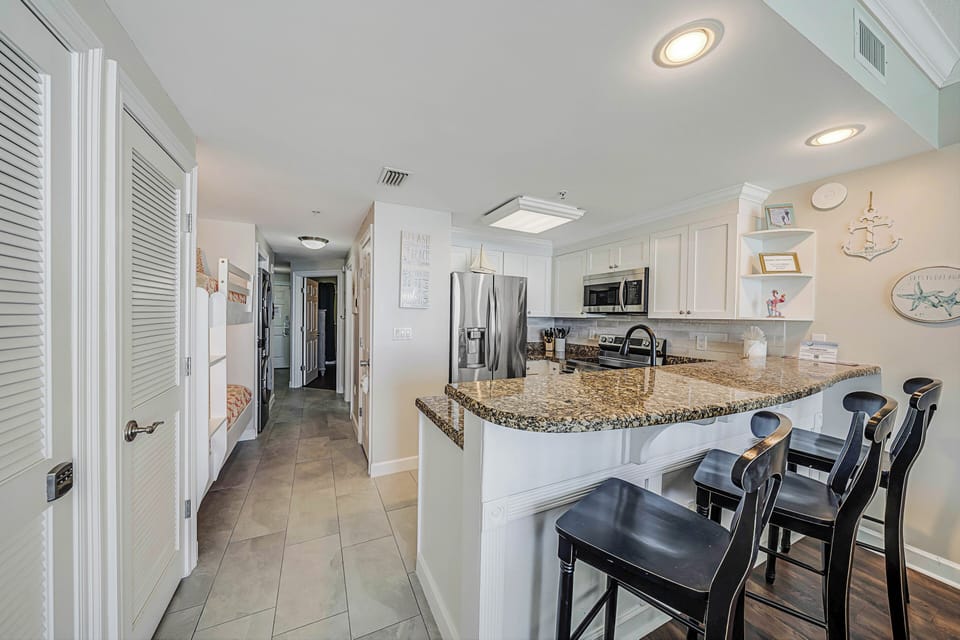 There is a small dining table, perfect for enjoying a meal or playing a game, as well as additional breakfast bar seating.