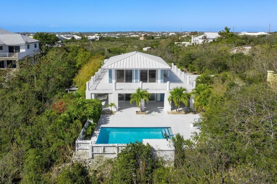 Aerial view of the front side of the house showing spacious patios and pool deck