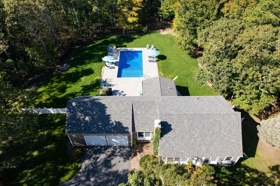 Aerial of the frontside of the house and back yard.