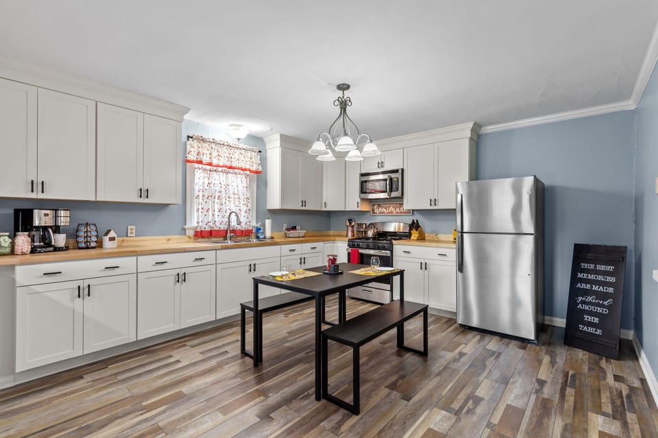 With dining table, butcher block counter tops, and stainless steel appliances