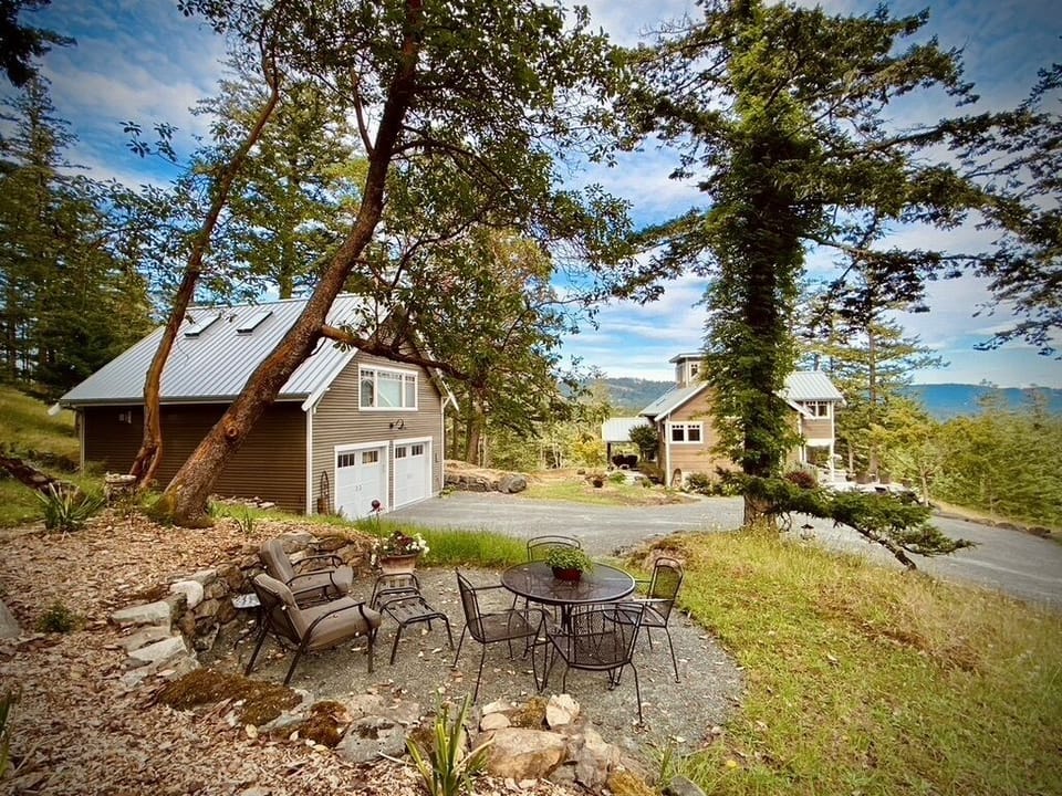 Private outdoor lounge area under Madrona Trees. Main house and Suite shown. 
