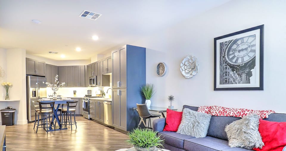 Relax in a cozy, light-filled living room with plush seating and a smart TV for your entertainment.