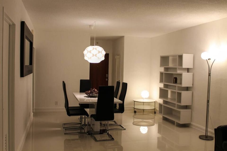 Sophisticated evening dining area with contemporary glass table, designer lighting, and elegant decor. Perfect for family dinners and special occasions with modern furnishings and ambient lighting creating the perfect atmosphere.