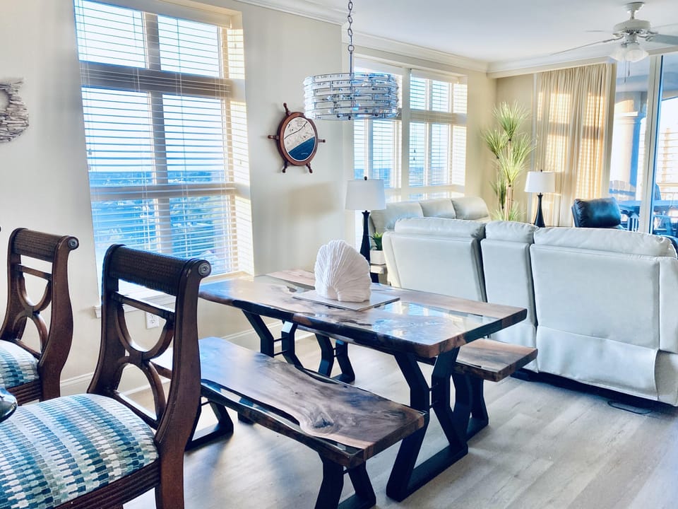 Sunlit dining area with panoramic water views and cozy seating