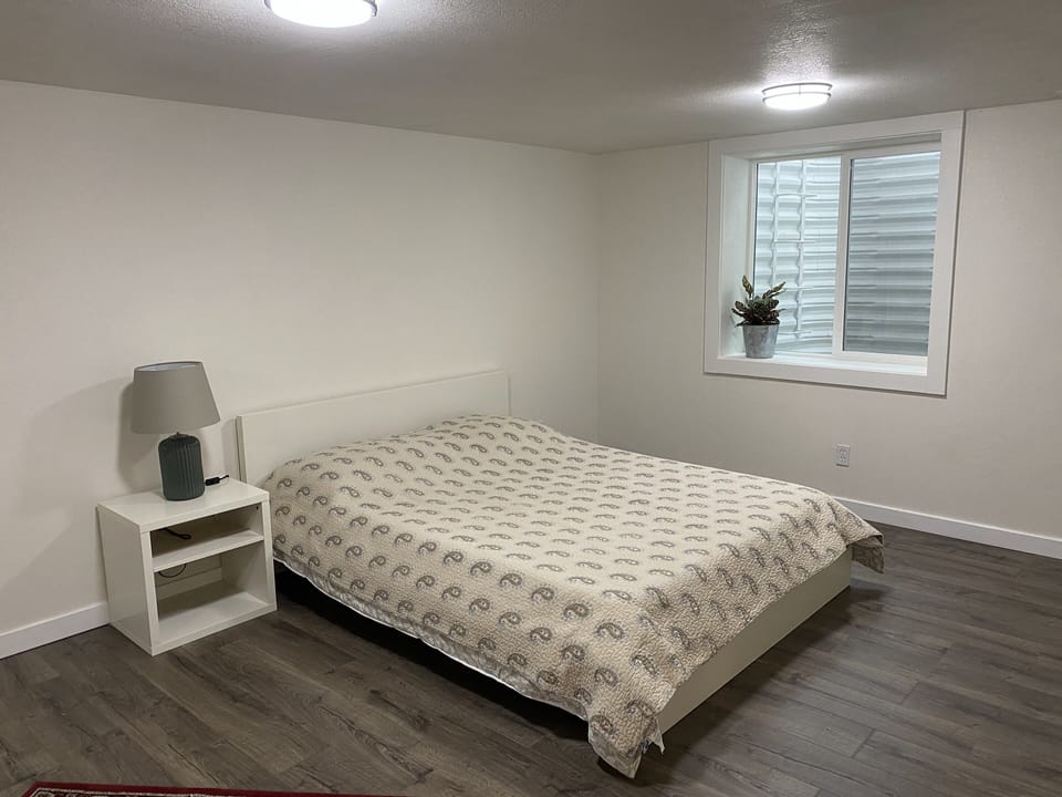 The queen bed in the large bedroom with the south facing window in the back.
