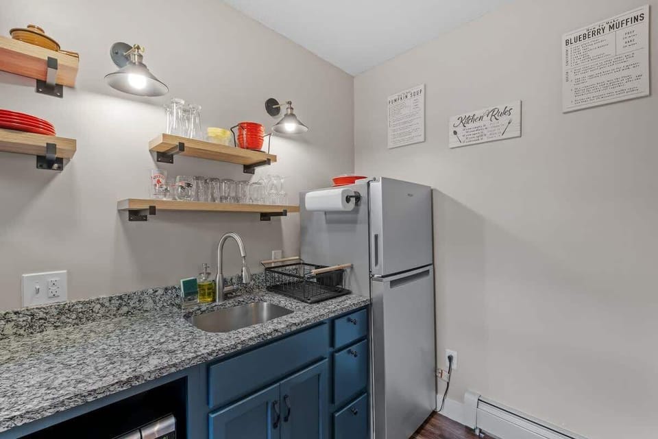 Enjoy a spacious full-size fridge, and chic exposed shelving adorned with thoughtfully arranged dishwasher