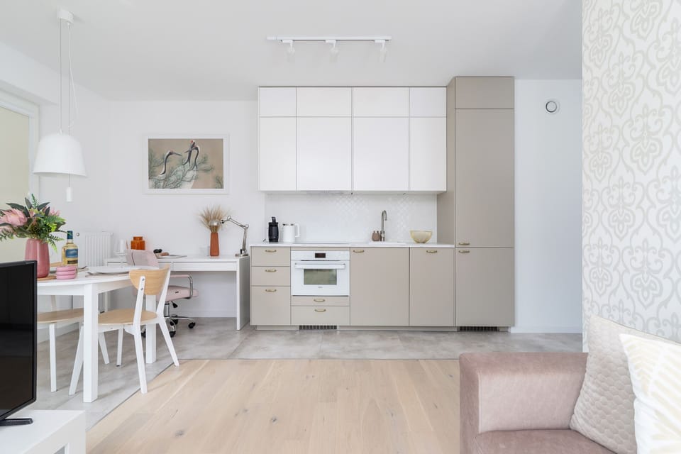 A functional kitchenette with bright furniture and high-quality appliances provides a comfortable cooking space.