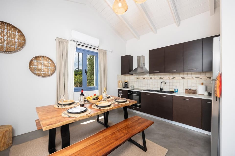 Open-plan living room with sofa, dining area, kitchen, ornamental fireplace, A/C, WiFi internet, and satellite TV