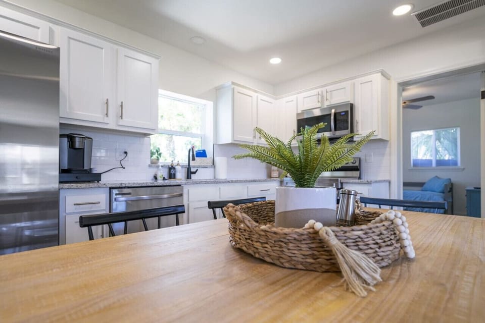 Fully equipped open kitchen and dining area with new appliances, stocked cookware, and a K-Cup Keurig—perfect for home-cooked meals.