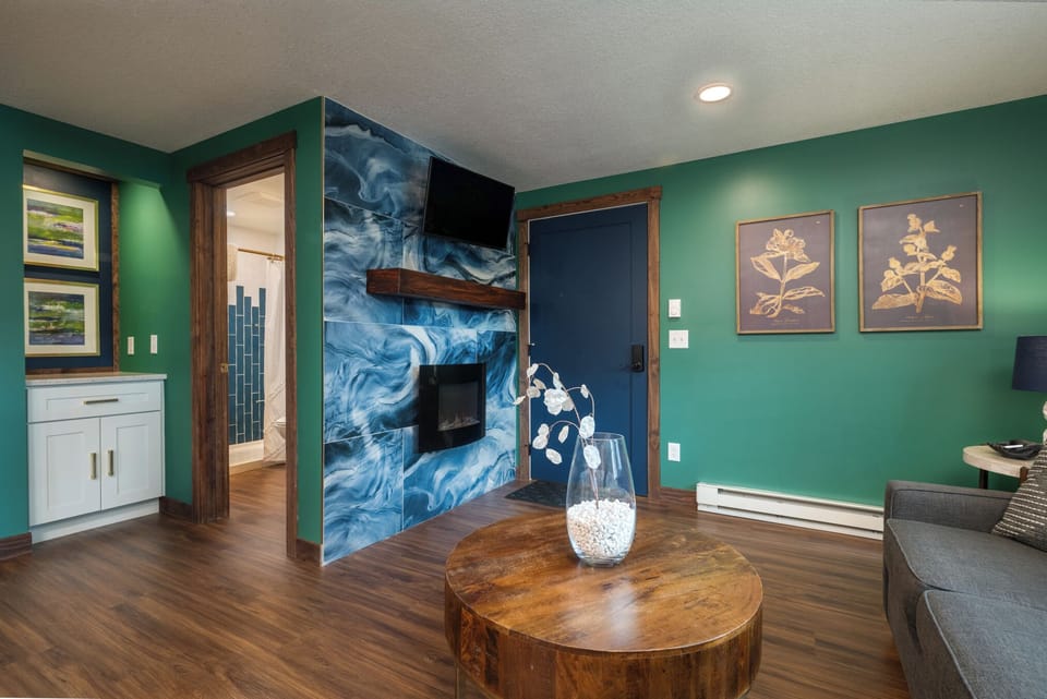 Cozy up in the Emerald’s living room featuring a soft sofa, electric fireplace, and smart TV with WiFi. Perfect for movie nights, morning coffee, or relaxing after a day of exploring downtown Prescott—just steps from your door.