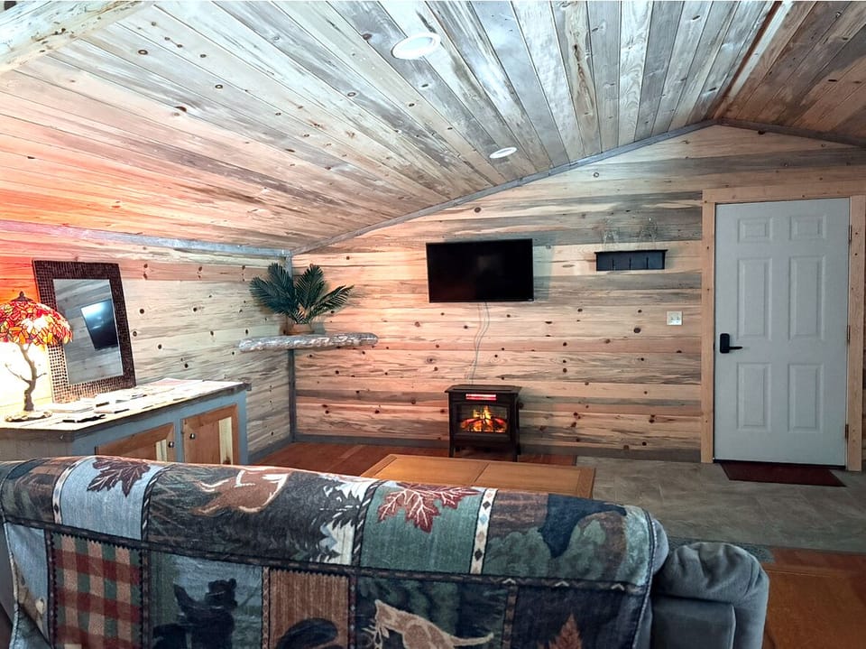 Living room, comfy couch, TV and electric fireplace.